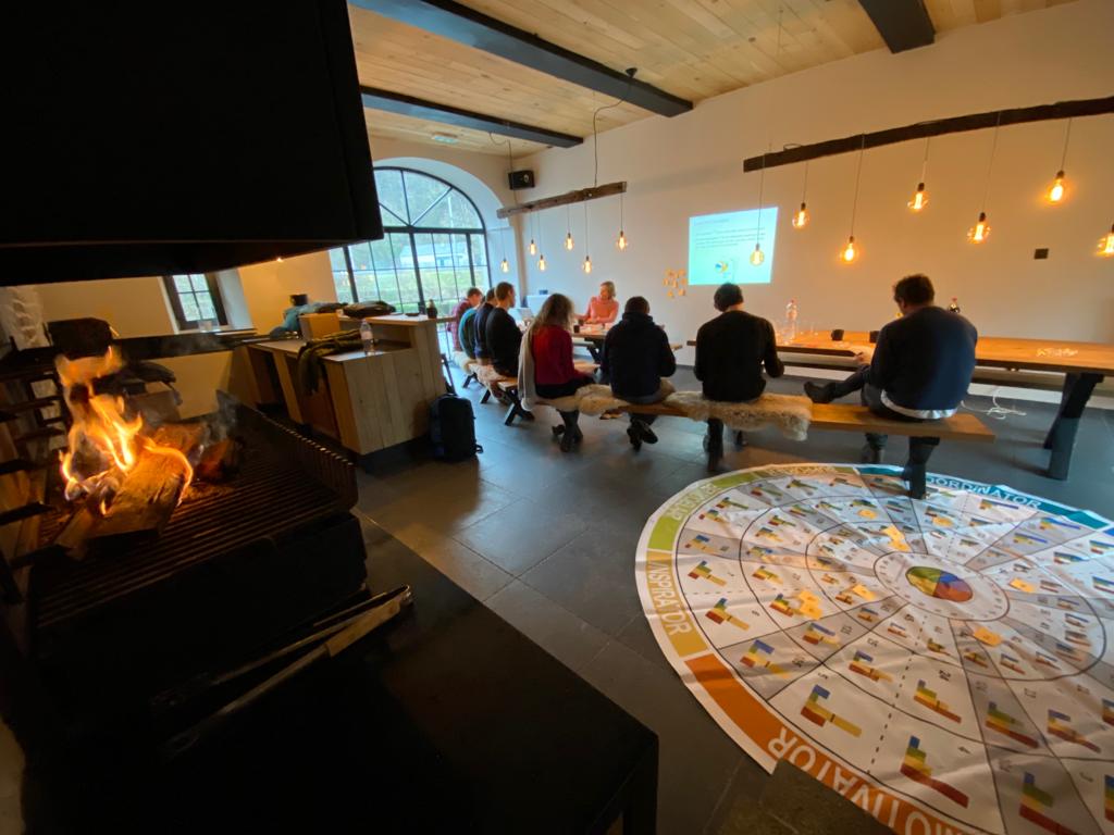 Een team tijdens een sessie in de ruimte met haardvuur