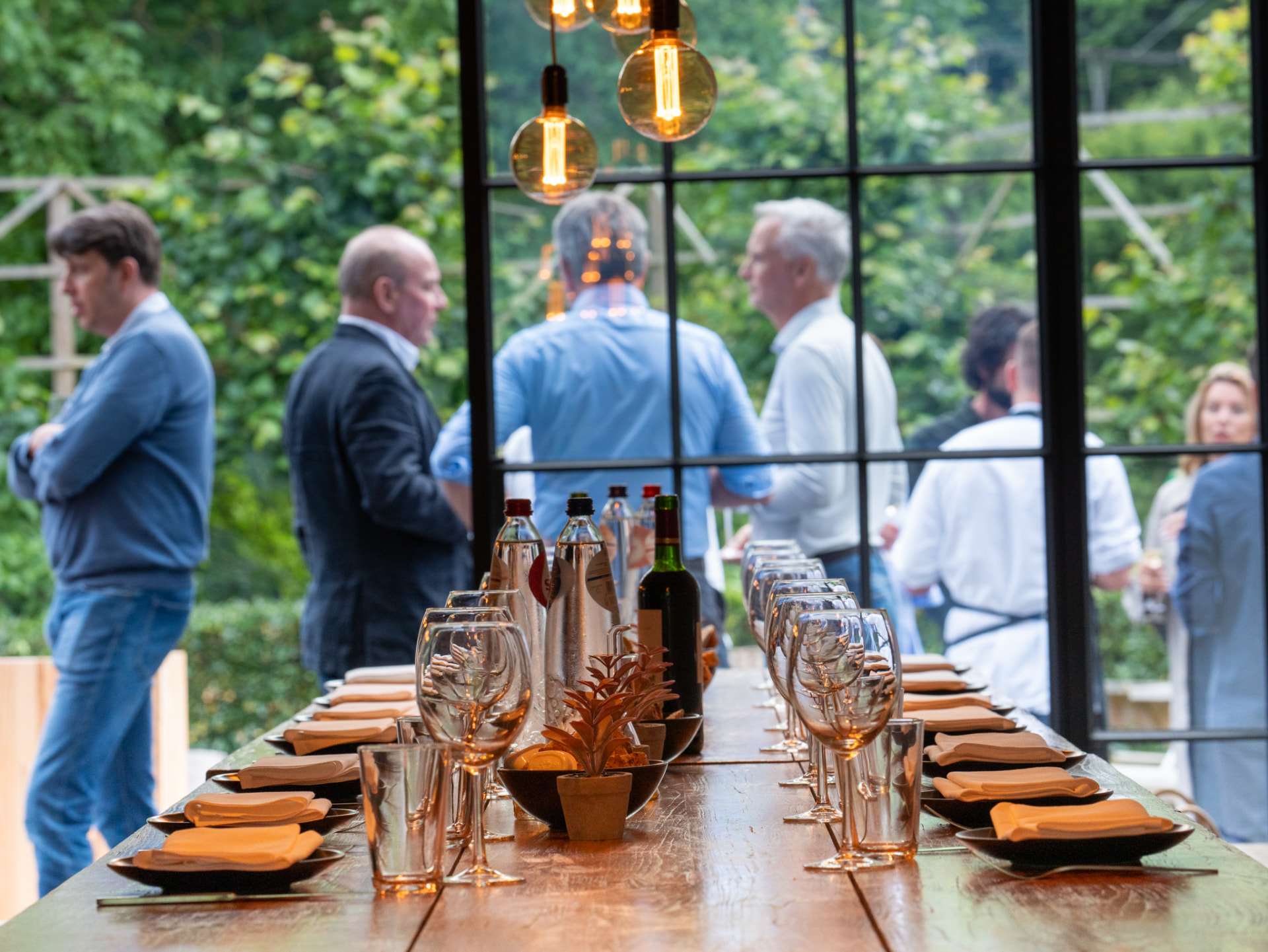 Gasten bij het aperitief aan de gedekte tafel voor het diner