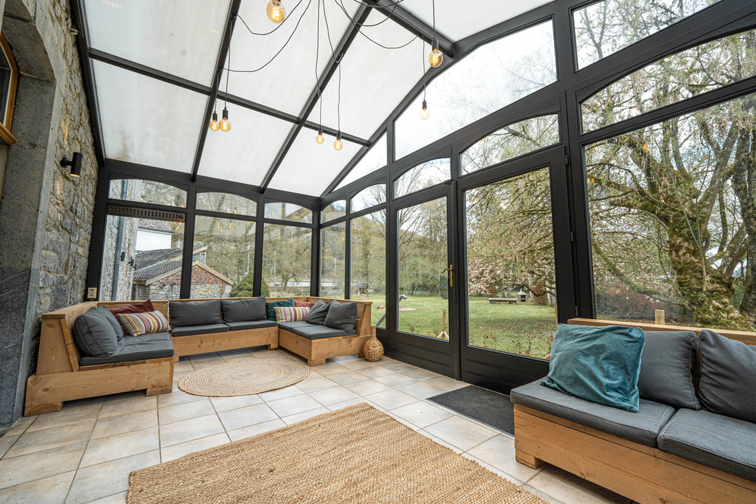 De lichte leefruimte van La Tannerie met zicht op de tuin